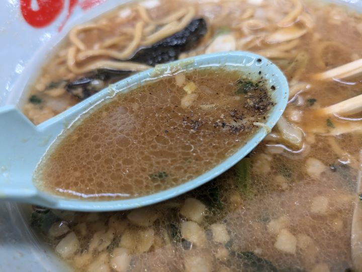 ラーメン山岡家の和節醤油とんこつラーメンのスープの写真