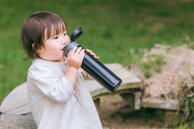 子供が水筒を飲んでいる写真