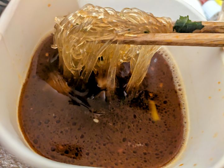 麻辣湯のさつまいも春雨を箸で持ち上げている写真