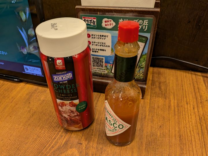 オリーブの丘のテーブルに常備されている粉チーズとタバスコ