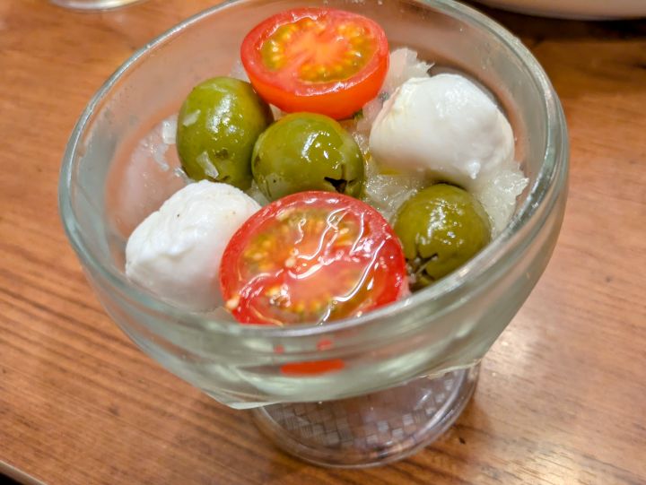 トマトとモッツァレラチーズに玉ねぎソースが添えられたオリーブの丘のカプレーゼ