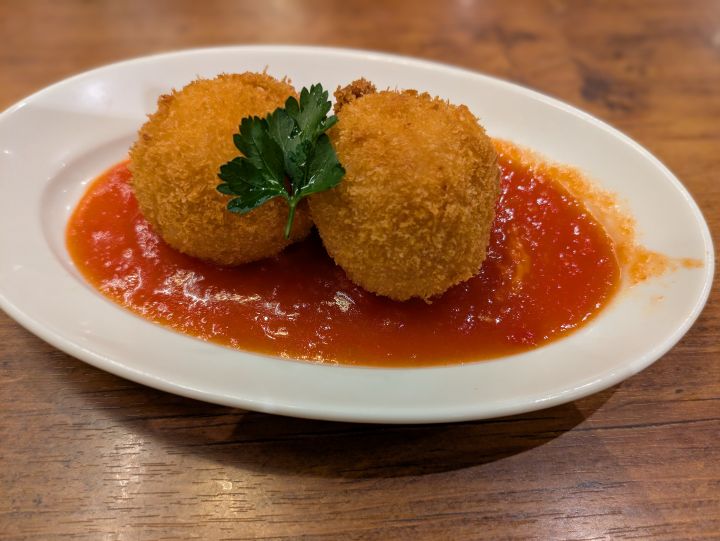 オリーブの丘のライスコロッケ（アランチーニ）、にんにくの効いたトマトソースとたっぷりのチーズ