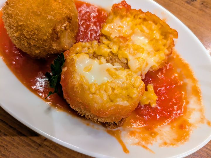 オリーブの丘のライスコロッケ（アランチーニ）、にんにくの効いたトマトソースとたっぷりのチーズ