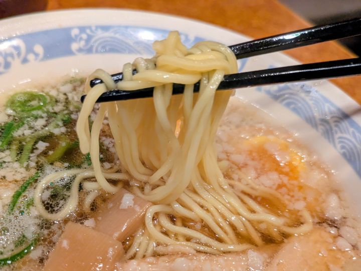 背脂醤油ラーメンの細麺を箸上げしている写真