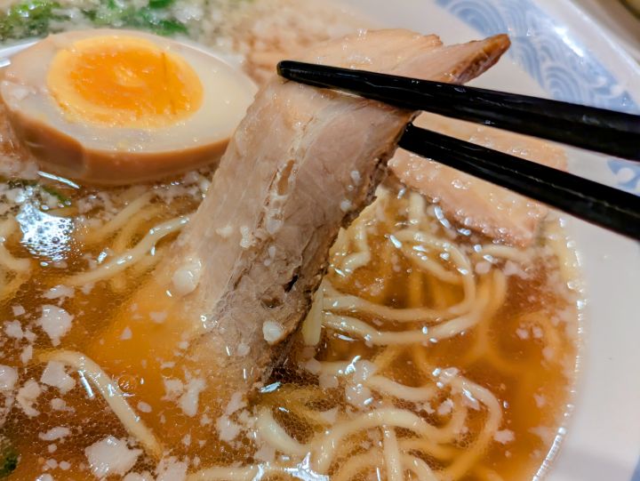 背脂醤油ラーメンに乗った自家製焼豚の写真