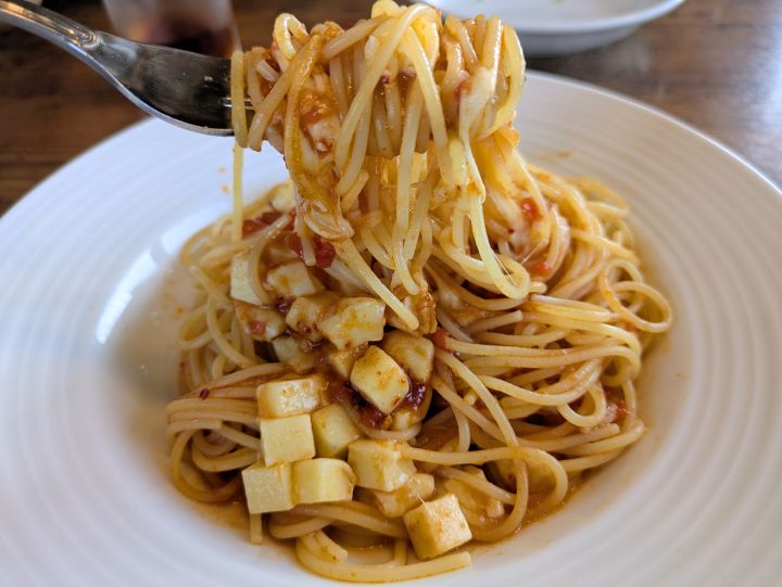 とろけるチーズが絡んだパスタをフォークで持ち上げた様子