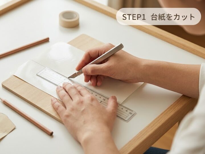 シール帳の作り方STEP1、剥離紙シートの台紙を定規とカッターでサイズに合わせてカットする様子