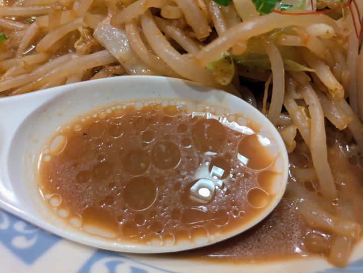 バーミヤン味噌バミ郎そばの味噌スープをレンゲですくったアップ