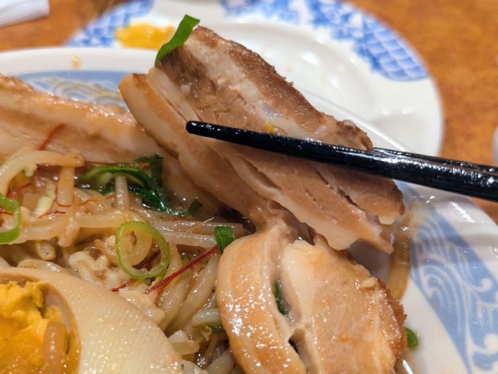 バーミヤン味噌バミ郎そばマシ盛の厚切り焼豚を箸で持ち上げたアップ